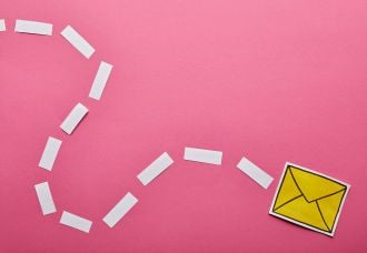 On a pink background, a yellow envelope is displayed with a squiggly dashed line toward it, giving a playful effect.