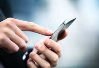 A photo of a hand tapping on a phone, symbolizing the act of contacting customer support.