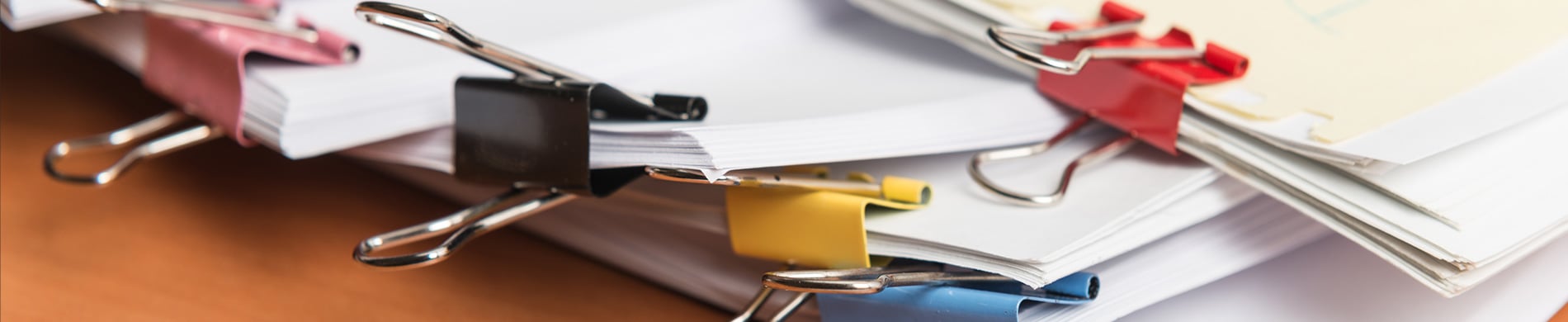 A photo of papers clipped together with jumbo paper clips, placed on a table.