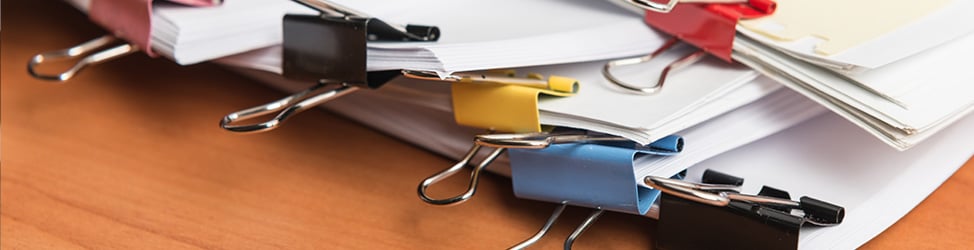 A photo of papers clipped together with jumbo paper clips, placed on a table.