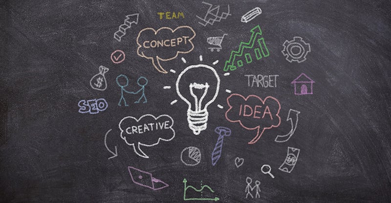 Feedback: Just State It A photo of a blackboard featuring a lightbulb drawn in the center with words like 'Creative,' 'Concept,' and 'Idea' written inside individual clouds surrounding the lightbulb.