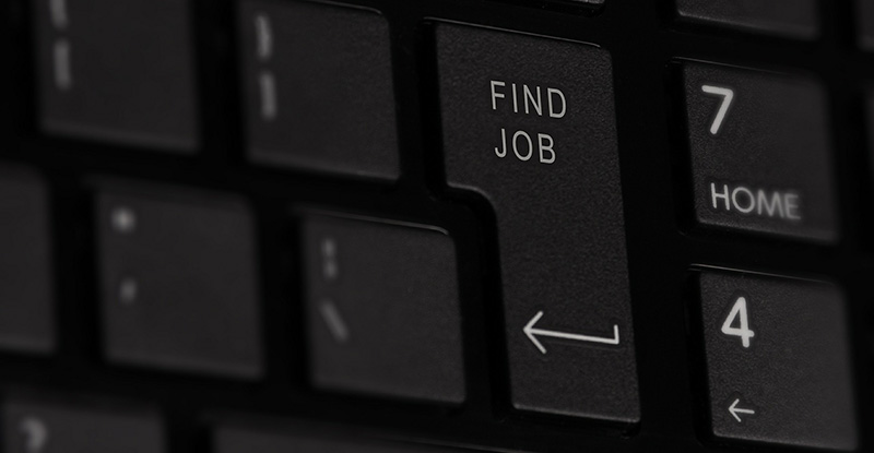 A closeup of a keyboard with a focus on the return key, which reads 'Find a job'.