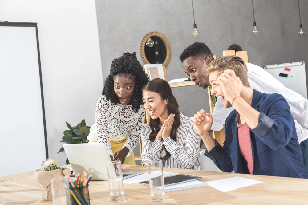 a group of people looking at a laptop