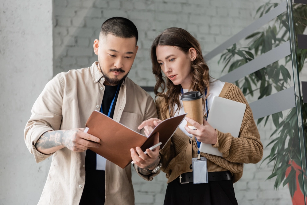 a man and woman looking at a book