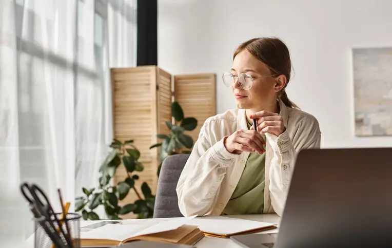 a woman sitting at a desk with a laptop