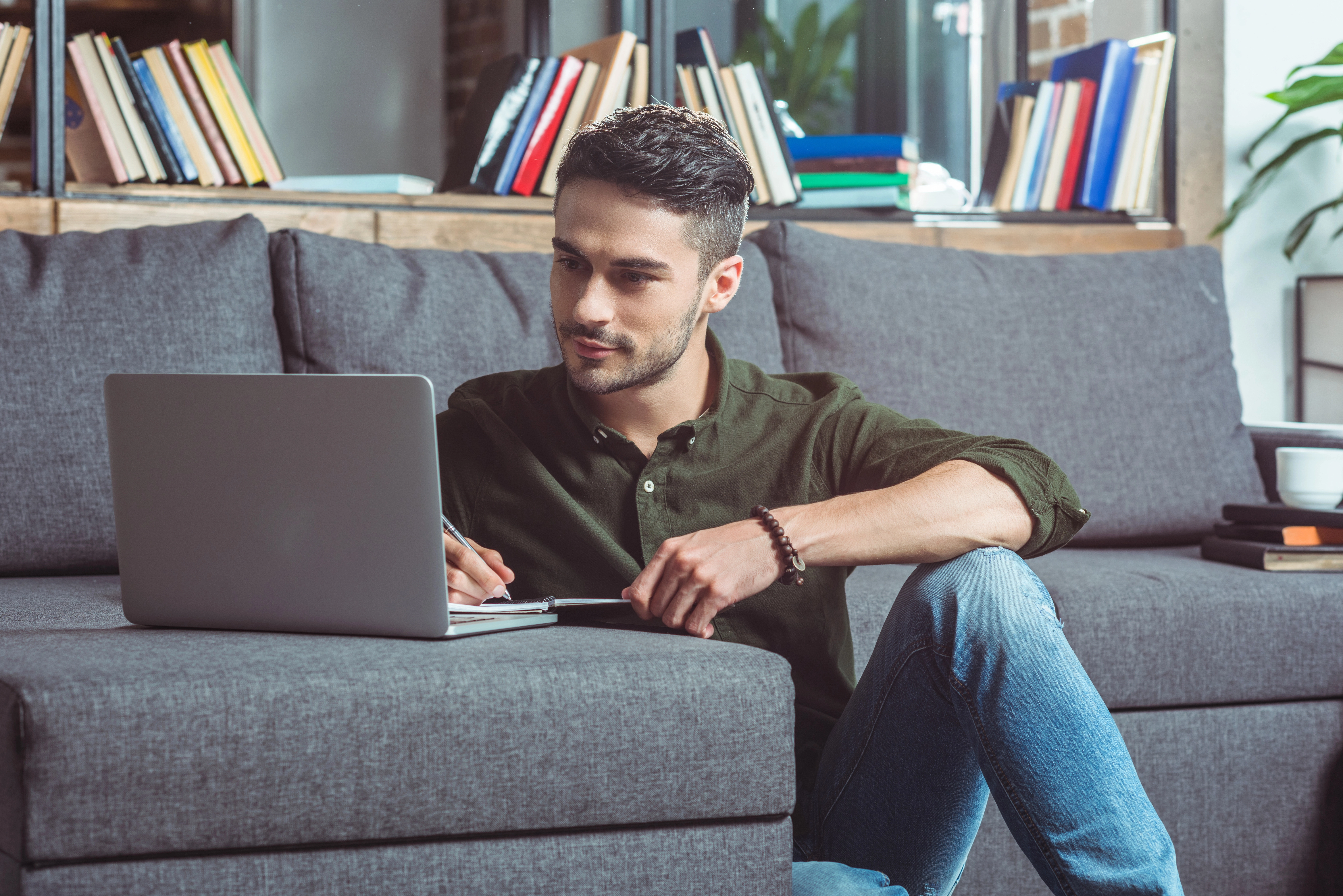 a man sitting on a couch using a laptop