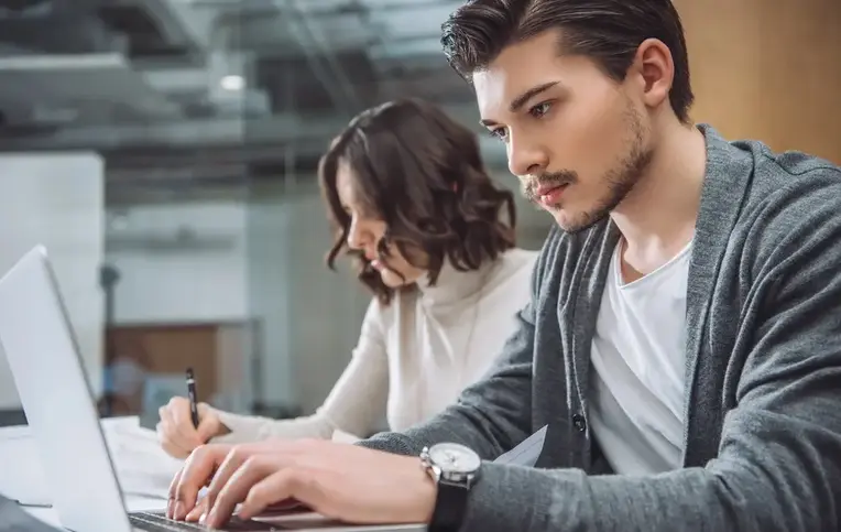 a man and woman sitting at a desk