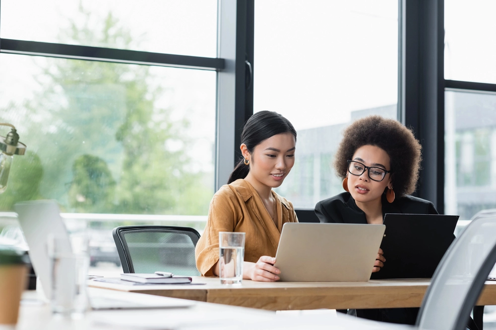 a group of women looking at a laptop