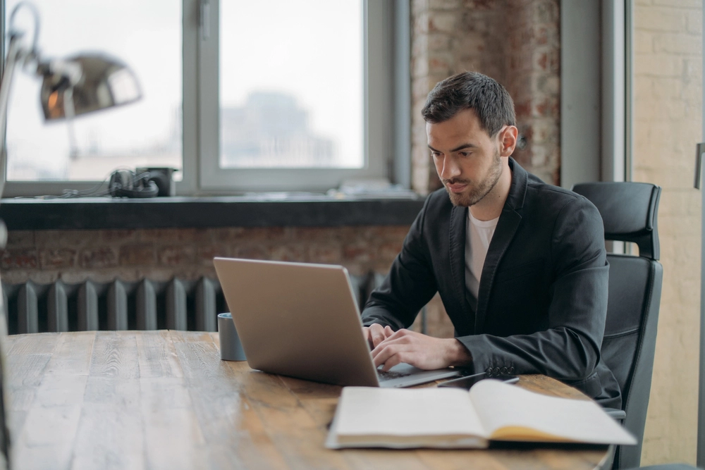 a man sitting at a table with a laptop