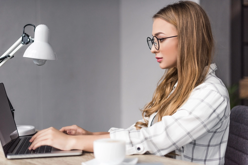 a woman sitting at a desk using a laptop