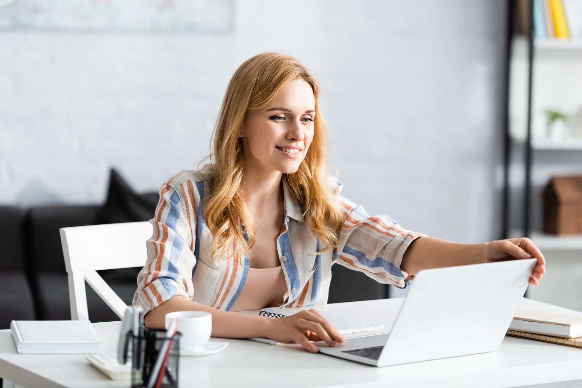 a woman sitting at a table with a laptop