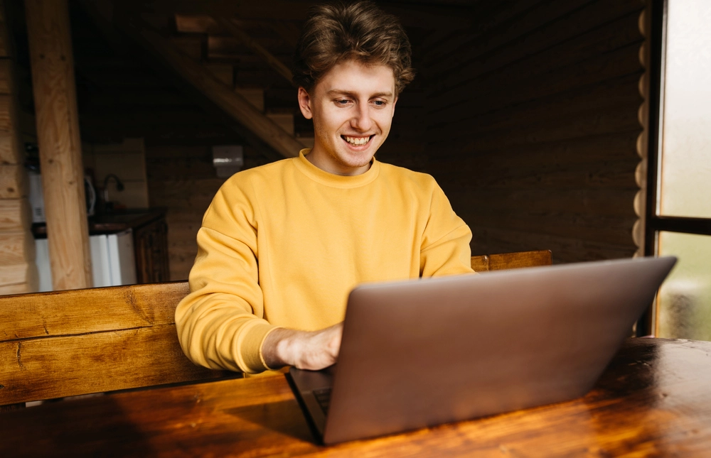a man smiling at a laptop