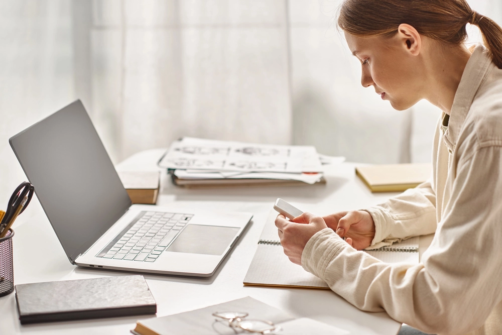 a woman sitting at a desk using a laptop