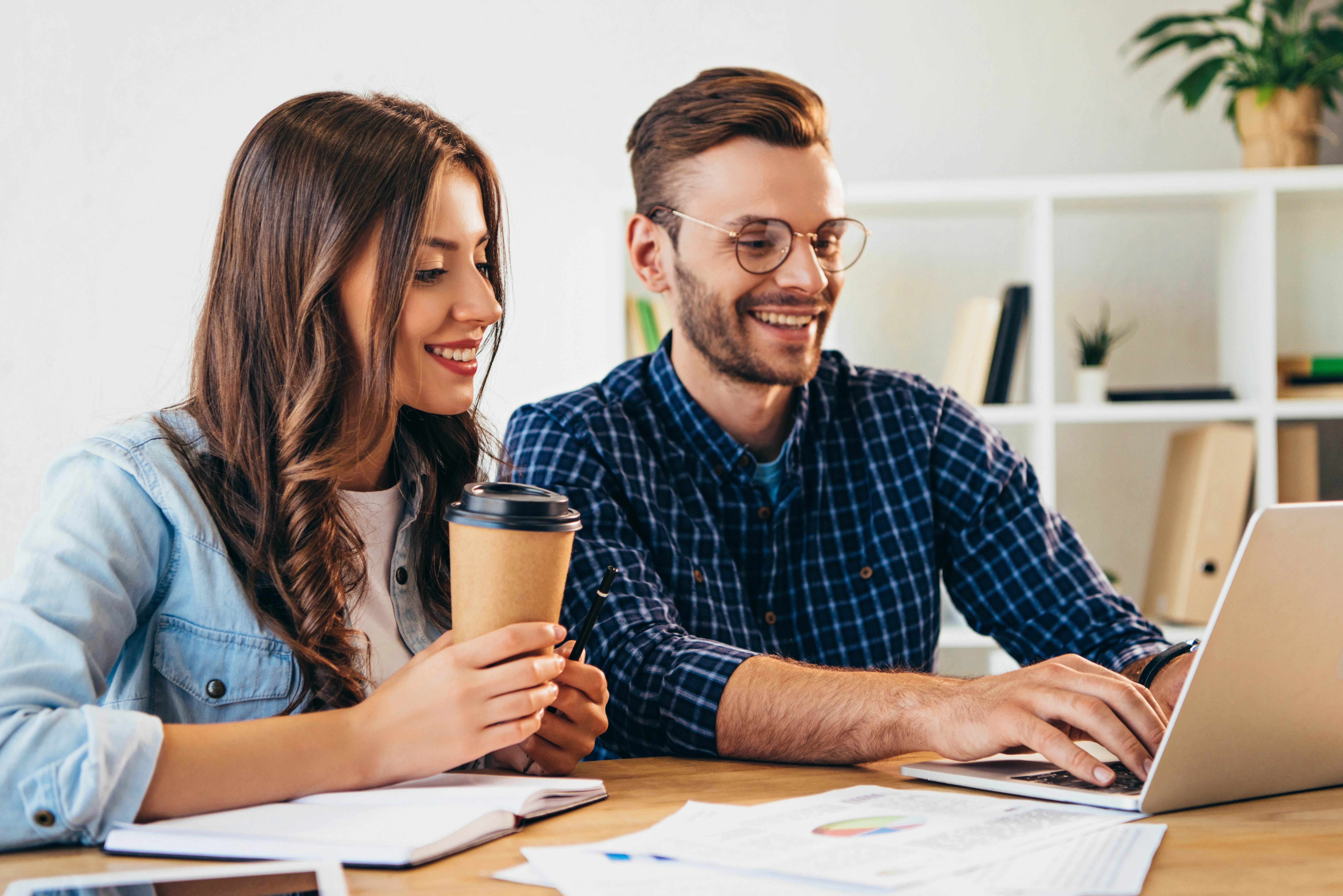 a man and woman looking at a laptop