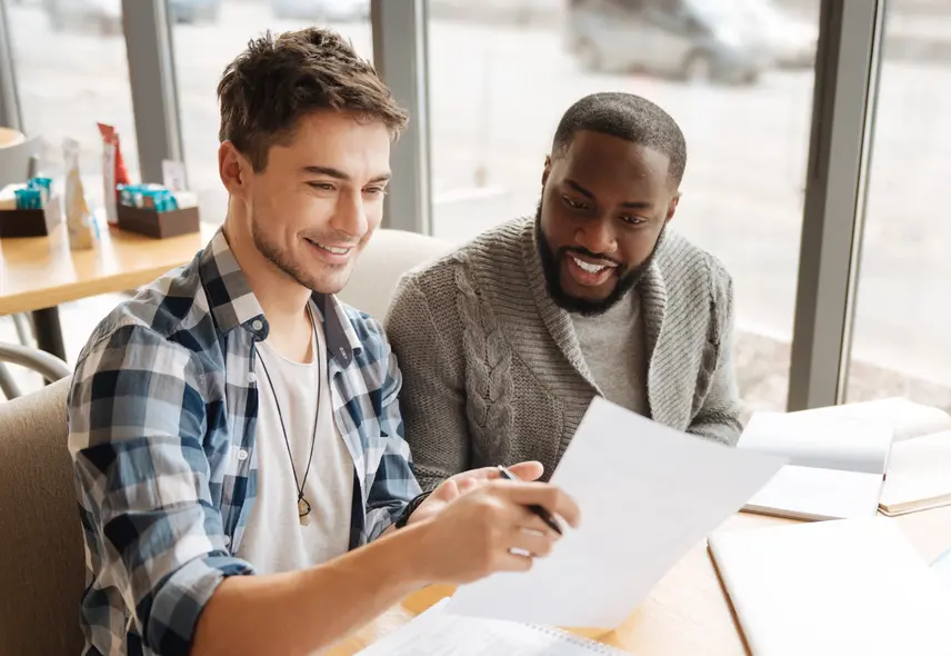 a couple of men looking at papers