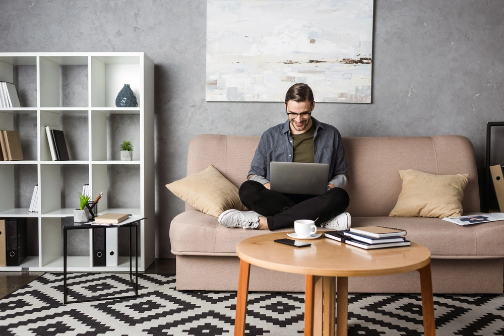 a man sitting on a couch using a laptop