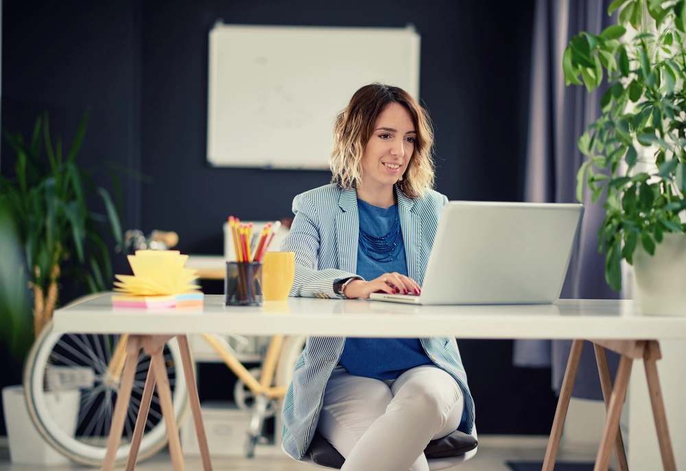 a woman sitting at a desk with a laptop