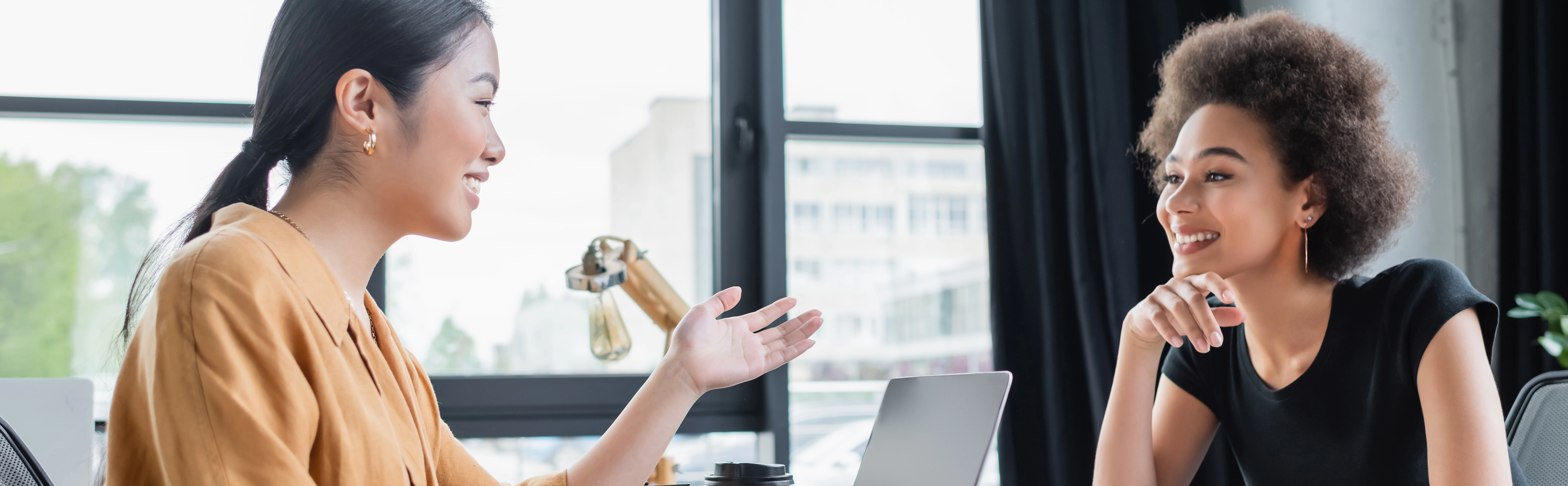 a person raising their hand in front of a laptop