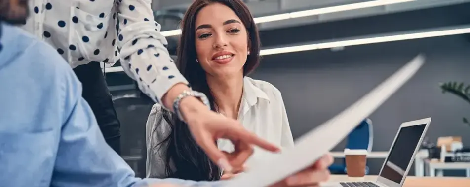 a woman pointing at a piece of paper