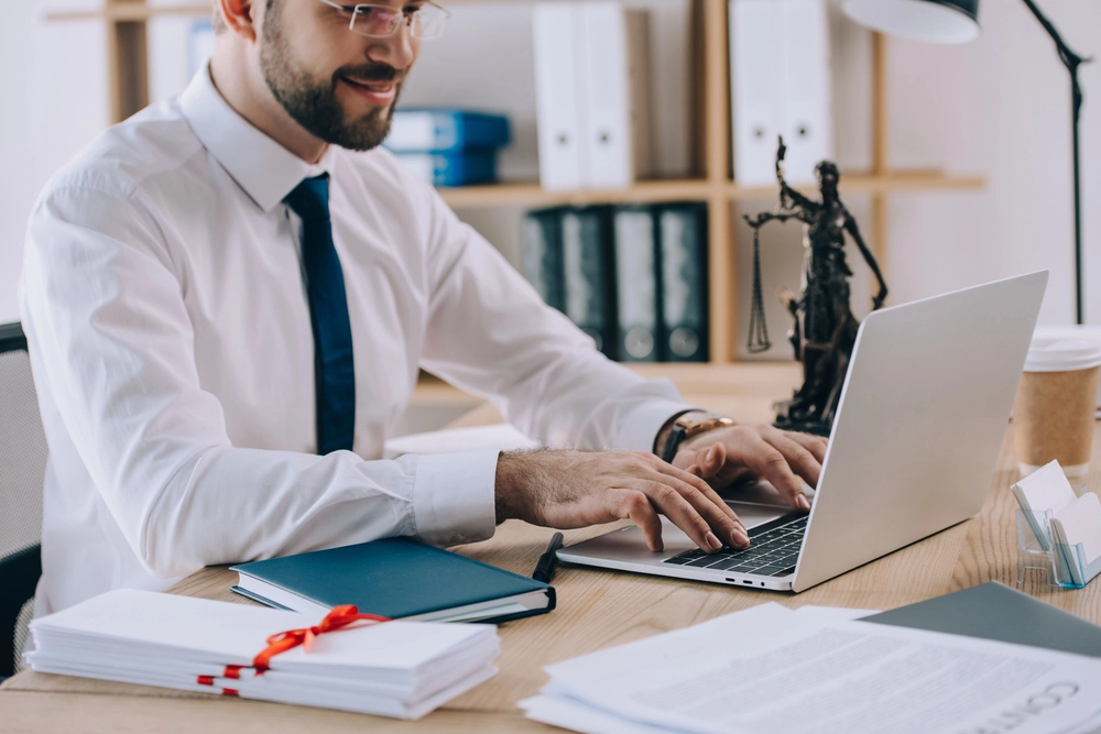 a man sitting at a desk using a laptop