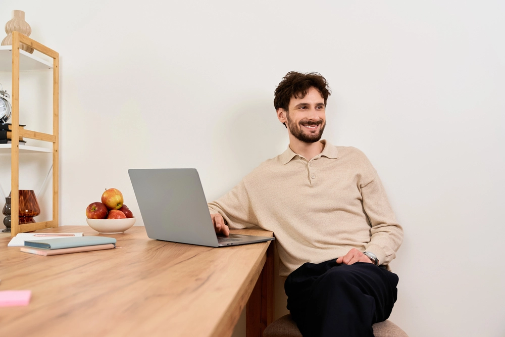 a man sitting at a table with a laptop