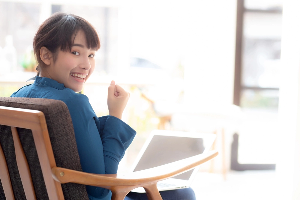 a woman sitting in a chair with her fist raised
