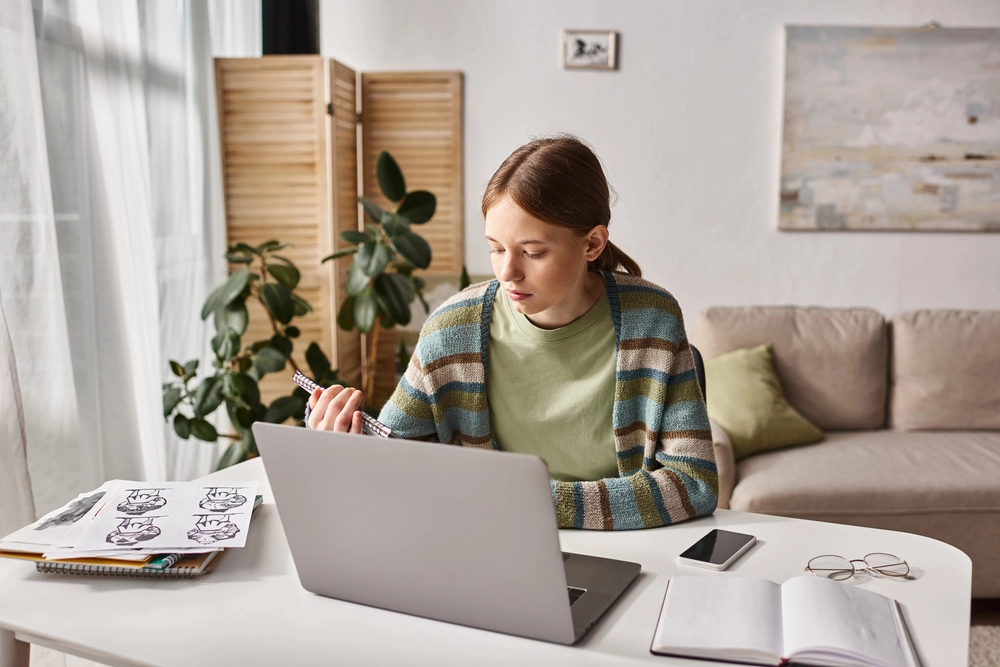 a woman sitting at a desk with a laptop