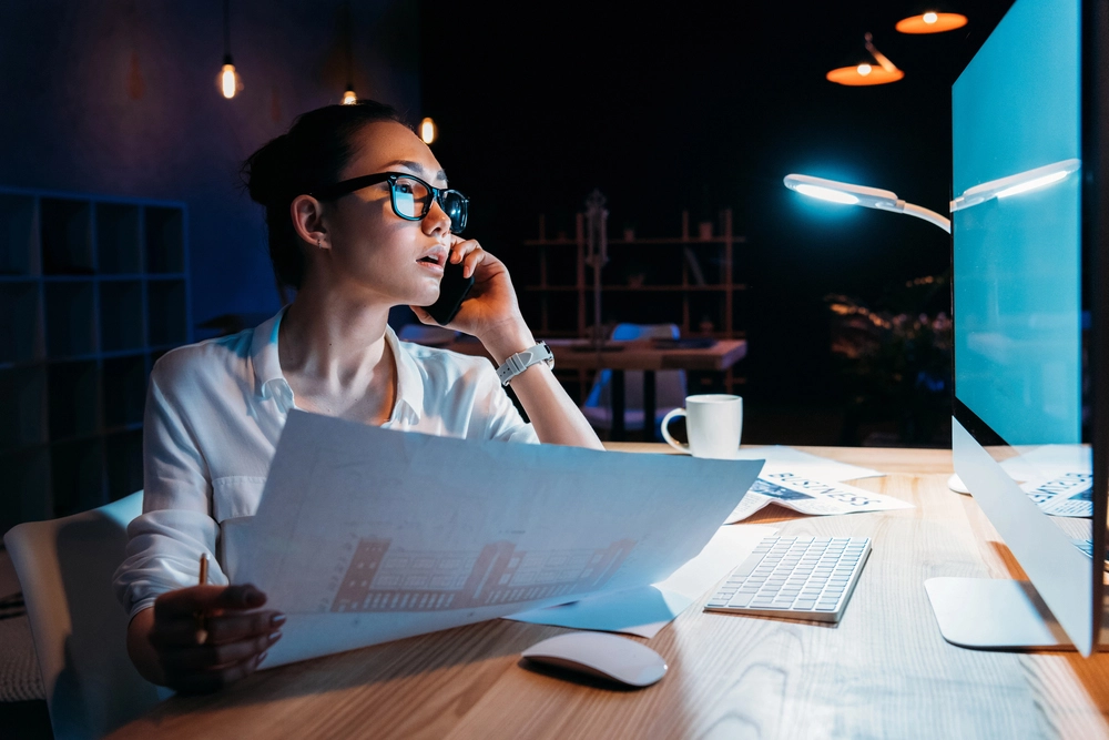a woman sitting at a desk talking on the phone
