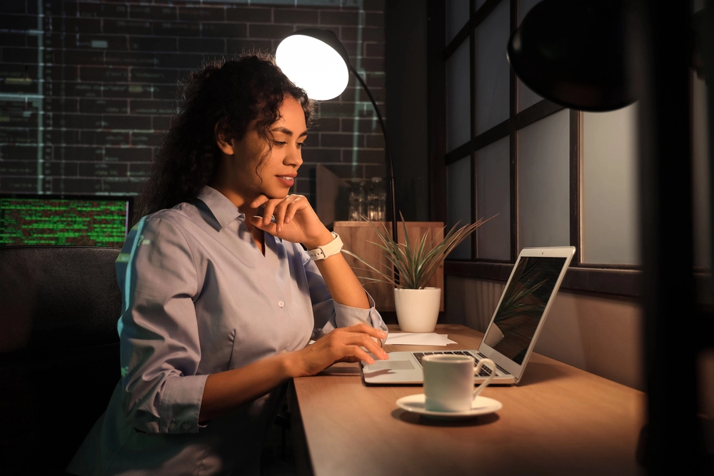 a woman sitting at a table with a laptop