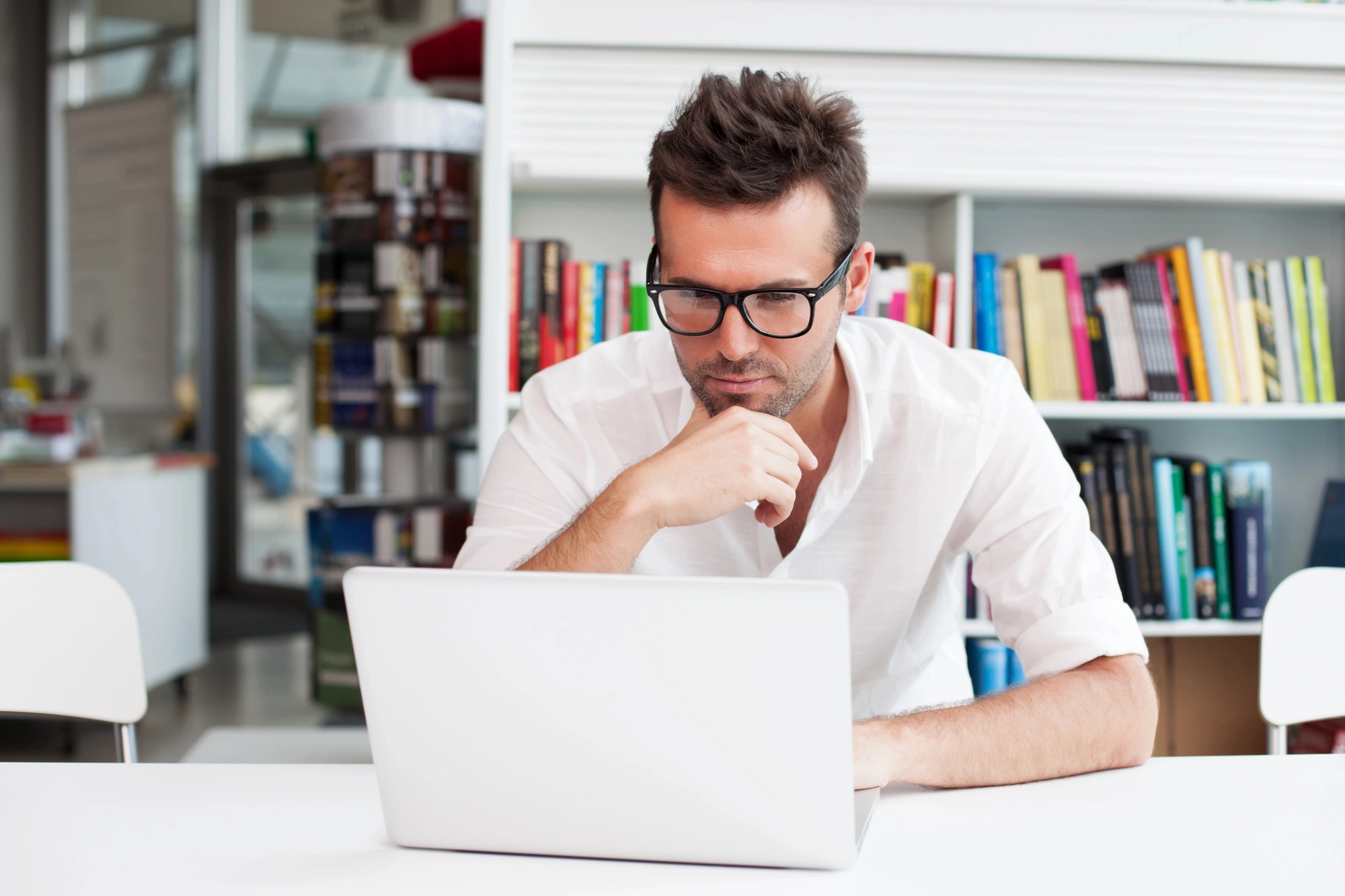 a man sitting at a desk with a laptop