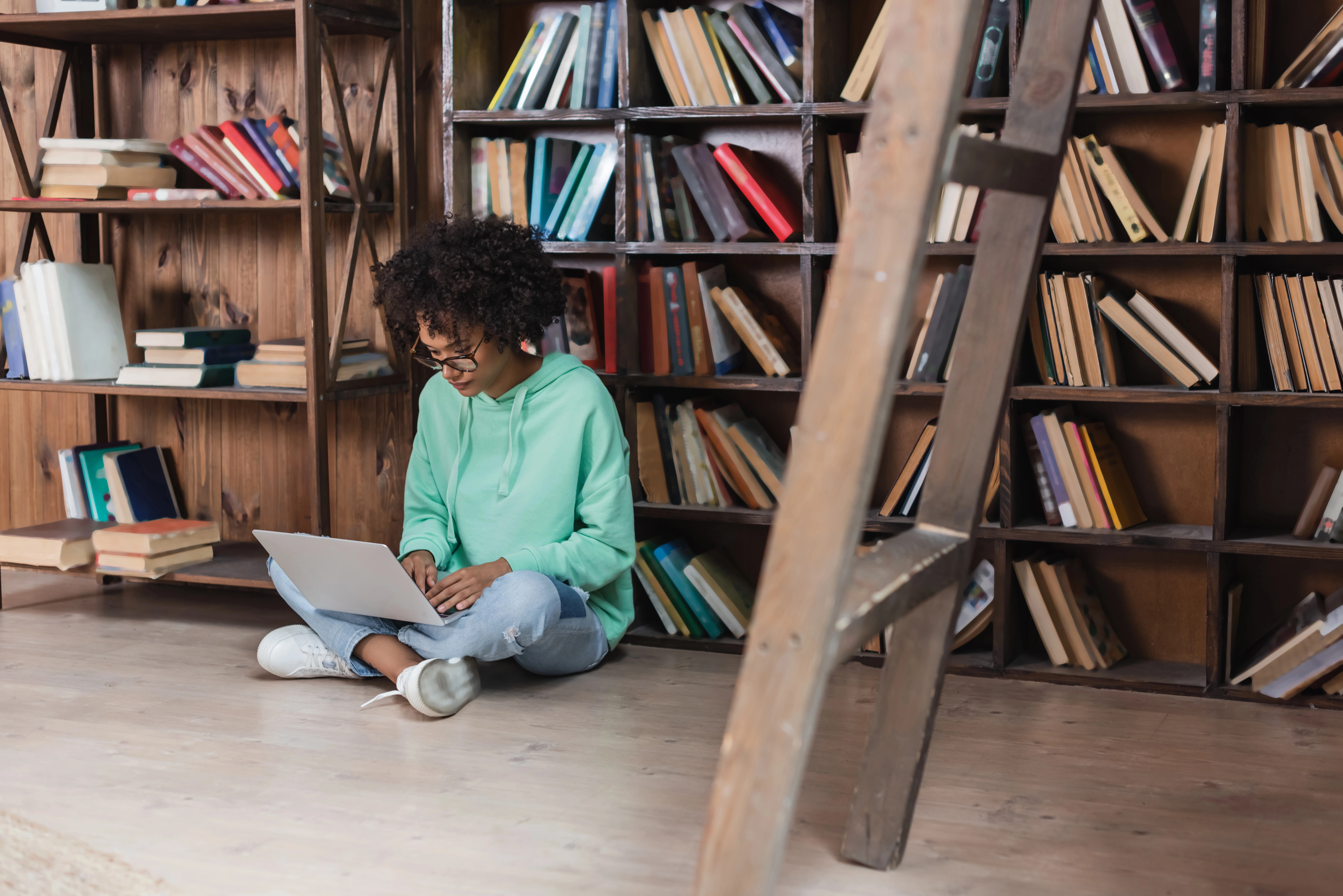 a woman sitting on the floor using a laptop