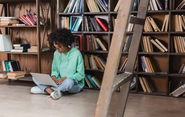 a woman sitting on the floor using a laptop