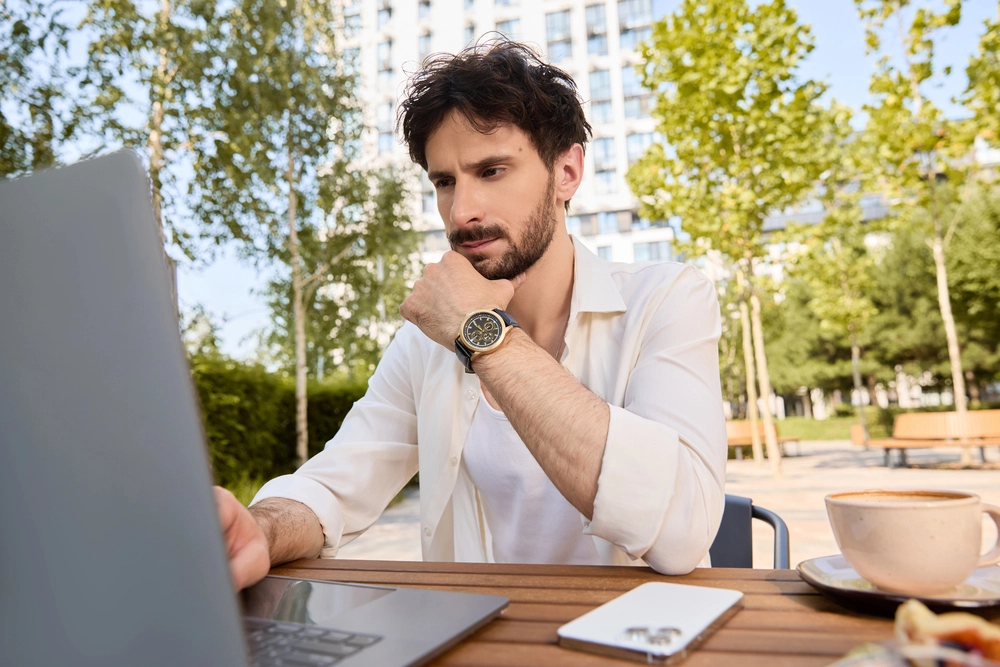 a man sitting at a table with a laptop