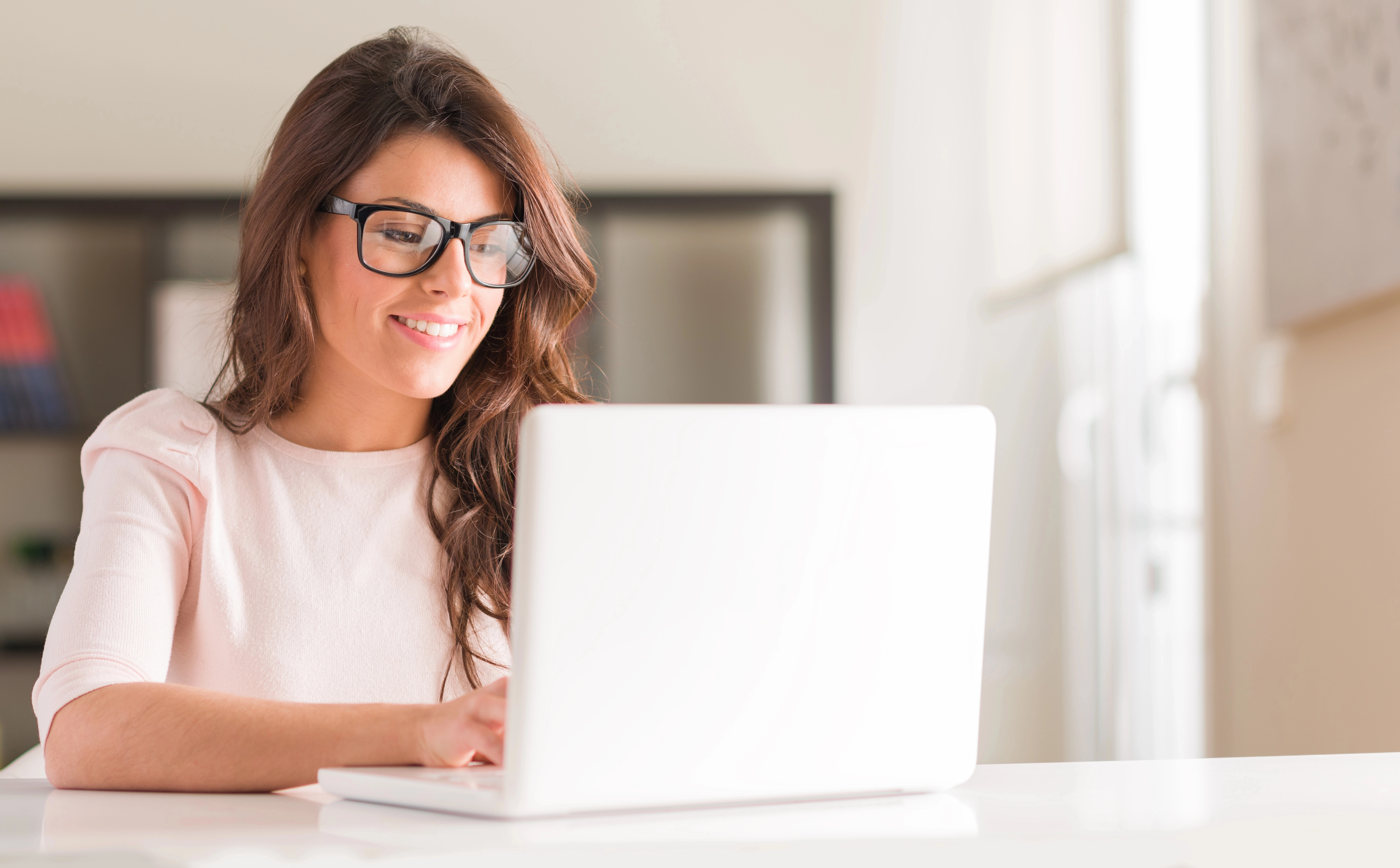a woman wearing glasses and using a laptop