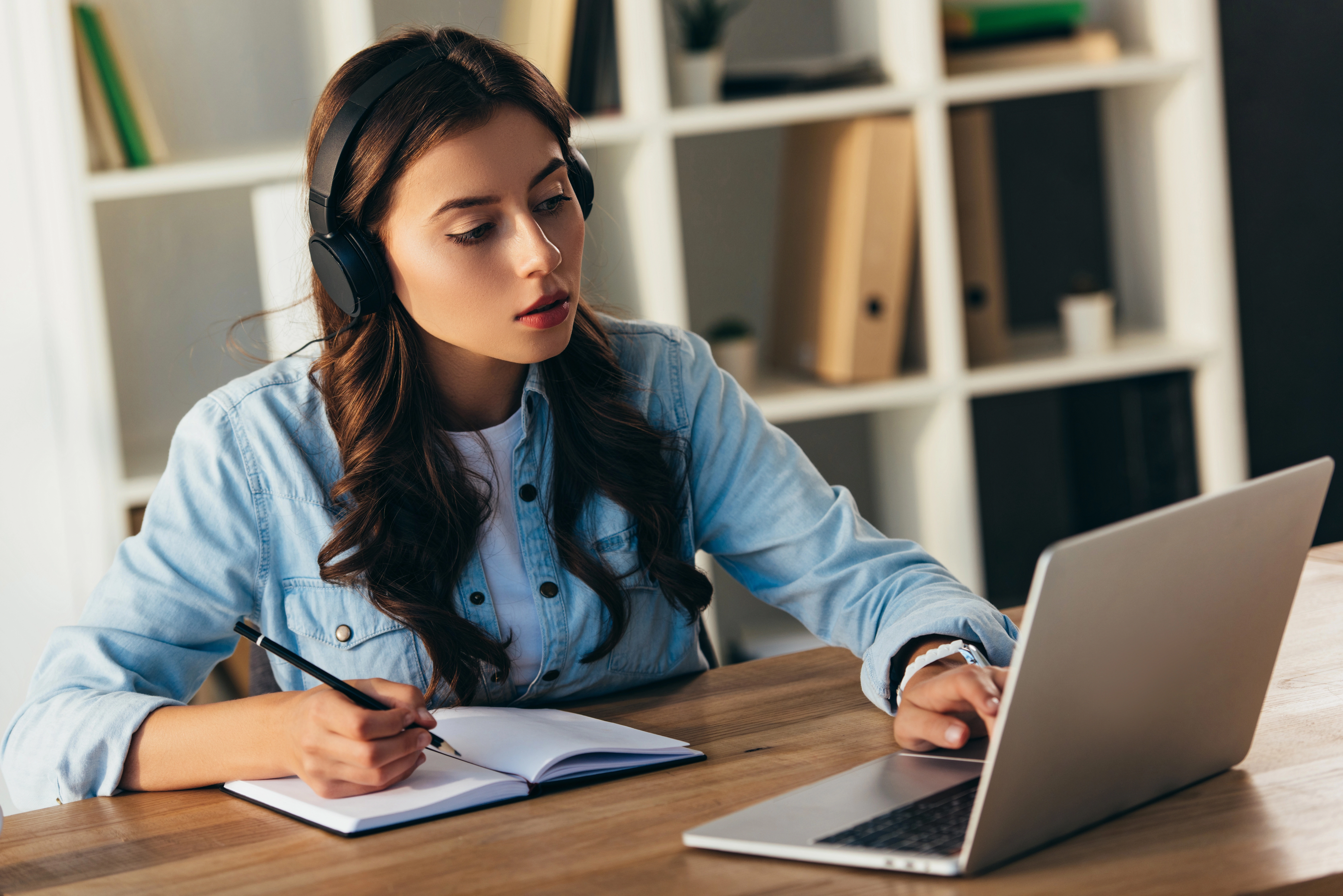 a woman wearing headphones and using a laptop