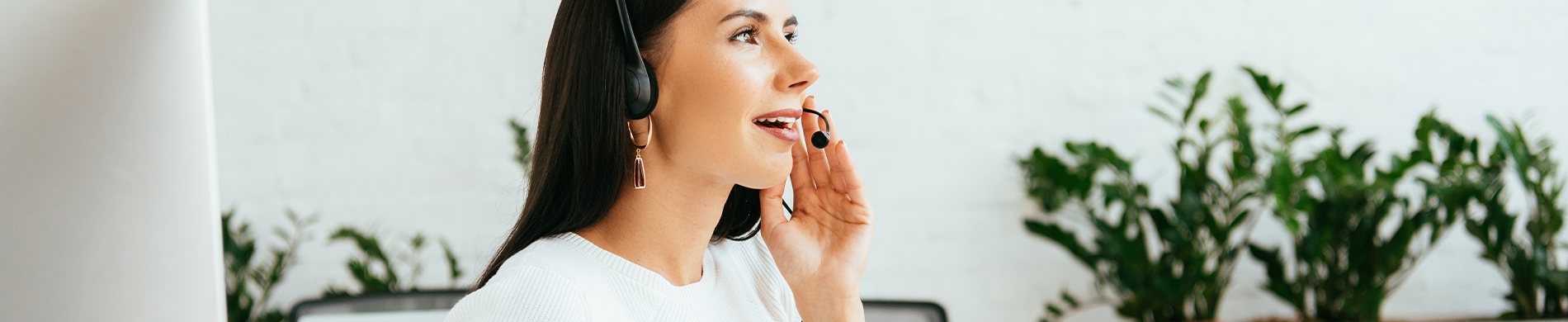 Banner A Caucasian woman wearing a headset, smiling and looking away.