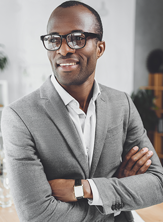 About CPAWSB An African man wearing a grey suite with glasses is posing for the camera while looking away.