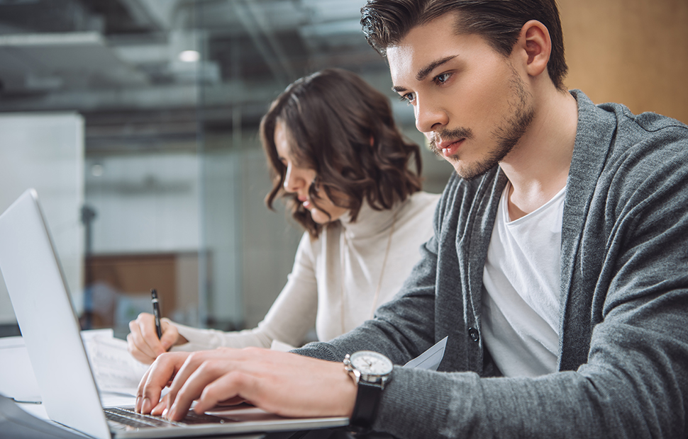 Exam Marking Opportunities An Asian student typing on a laptop, with another student visible in the background.