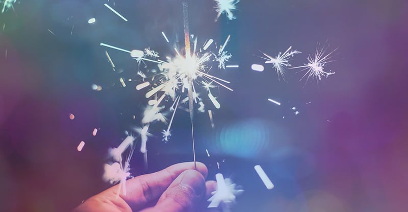 Lauren Holland, CPA - Winner of 2021 KBH Exemplary New Professional Award A photo of a person holding a sparkler creating a whimsical look.