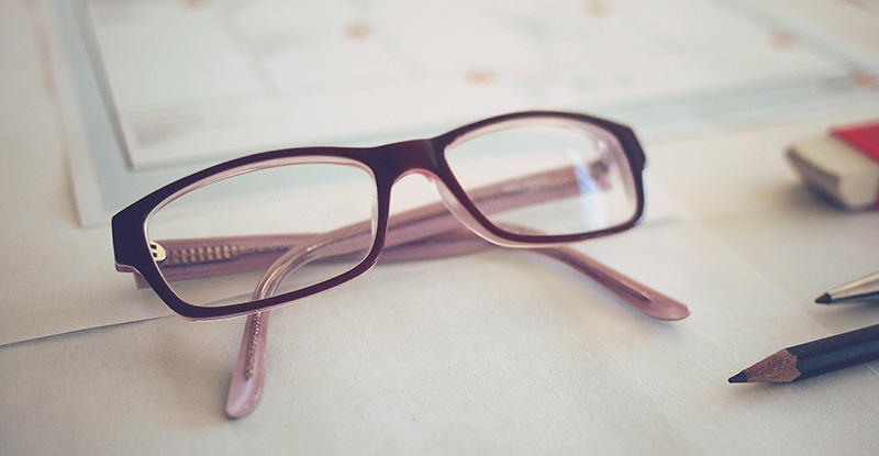 A photo of a table with an eye glass in focus.