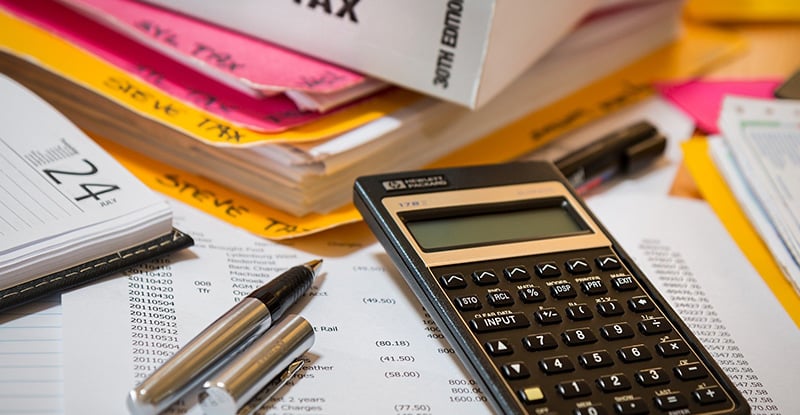 How do I access my tax receipt? A photo of tax papers spread out on a table with a calculator placed at the top.