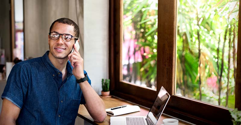 Study permit requirements for the CPA preparatory courses A photo of an ethnic man smiling while on the photo looking away. There is a laptop on the table with a window overlooking a garden.