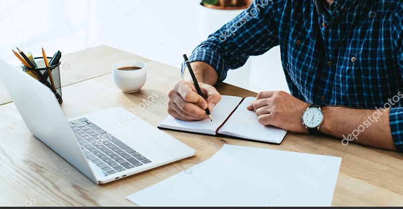 Update on CPA PEP Workshop Format 2021 A Caucasian man wearing a blue and black checked shirt, writing on a notebook while looking at his laptop.