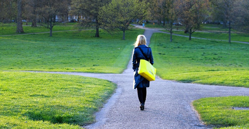 Career Progression, Part 3: Moving on A photo of a woman with a yellow bag walking in a park.