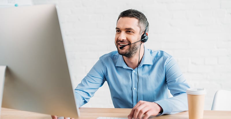 New Service - Connect with a CPAWSB Pre-professional Education Student Experience Advisor A Caucasian man with a headset smiling and looking at his computer. There is a coffee cup on the right side of the desk.