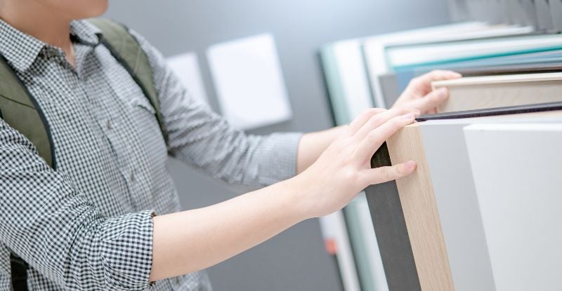 A photo of a student with a bag pack opening a filing cabinet.