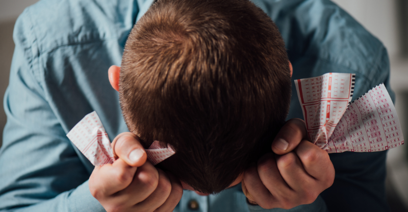 Regrouping after failing a CPA preparatory course exam A photo of a student holding his head in his hands with crumpled scantron sheets indicates that he has been unsuccessful in the test.