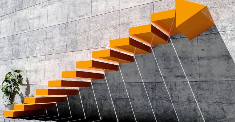 What does my CPA preparatory course grade mean? An illustration of a concrete wall with floating orange staircase with the top step ending in an arrow.