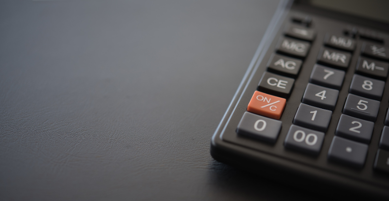 Can my employer pay for my CPA Education? A photo of a calculator visible partially on a grey desk.