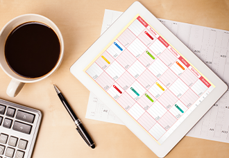 CPA PEP Schedule A photo taken from above, showing a coffee cup, pen, calculator, and a calendar placed on a table.